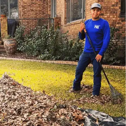 Macario Brothers crew member raking leaves in a San Antonio front yard