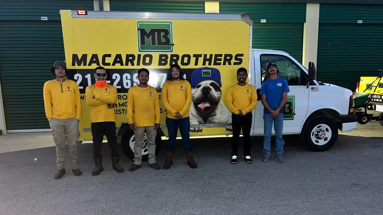 Macario Brothers Lawn Care crew in yellow shirts beside branded box truck in San Antonio